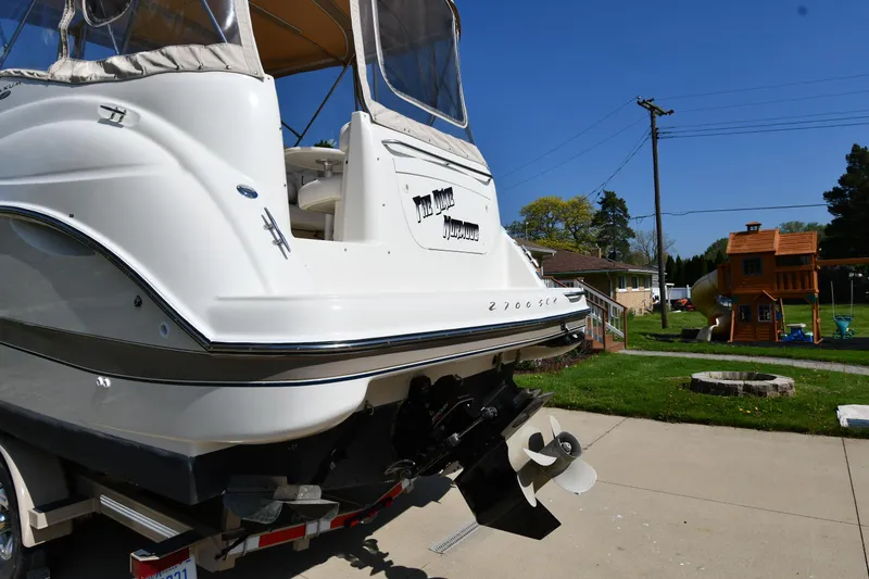 Slide: The Image of 2000 Maxum 2700 SCR boat on trailer, parked in driveway with backyard view. - 6