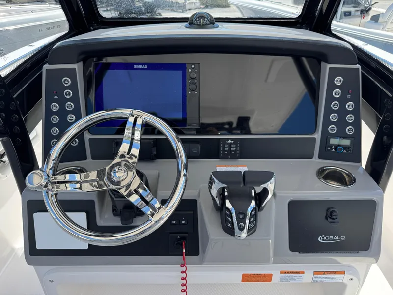 Slide: The Image of 2025 Robalo R270 Center Console dashboard with steering wheel and navigation controls. - 11