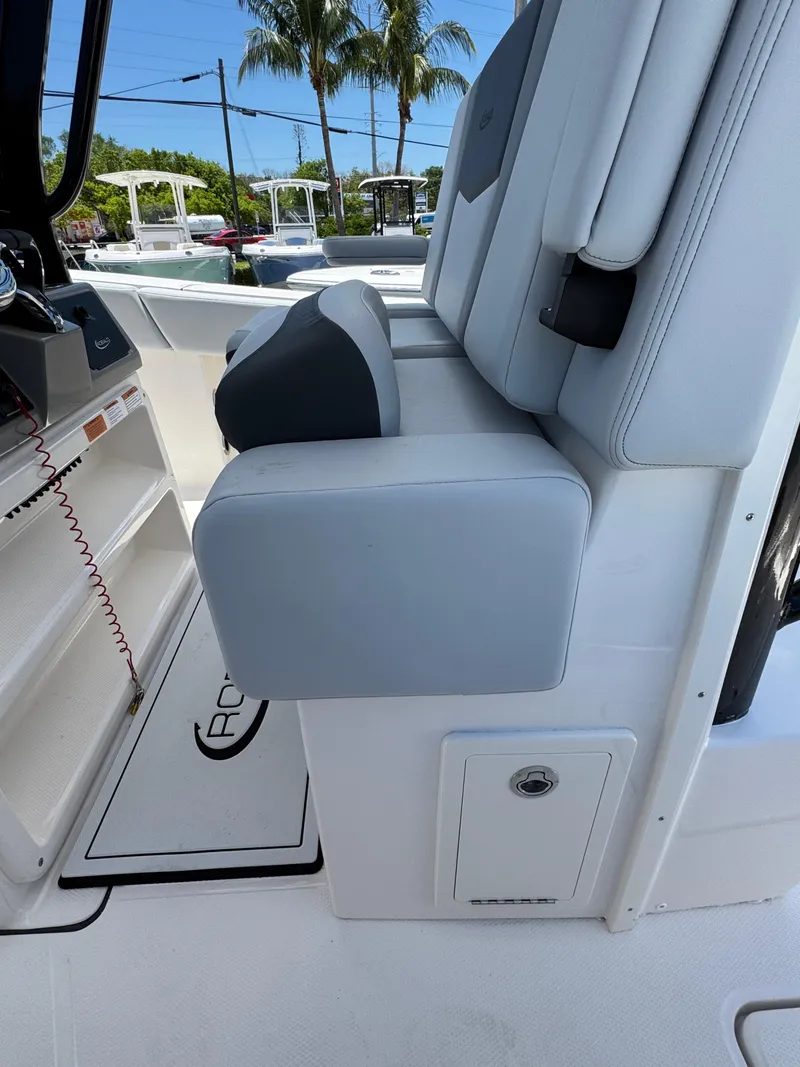 Slide: The Image of 2025 Robalo R270 Center Console boat interior with cushioned seating and storage compartment. - 13
