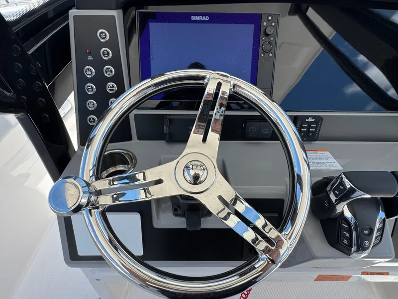 Slide: The Image of 2025 Robalo R270 Center Console steering wheel and dashboard with Simrad display. - 17