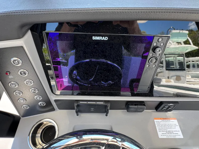 Slide: The Image of 2025 Robalo R270 Center Console dashboard with Simrad display and control buttons. - 18