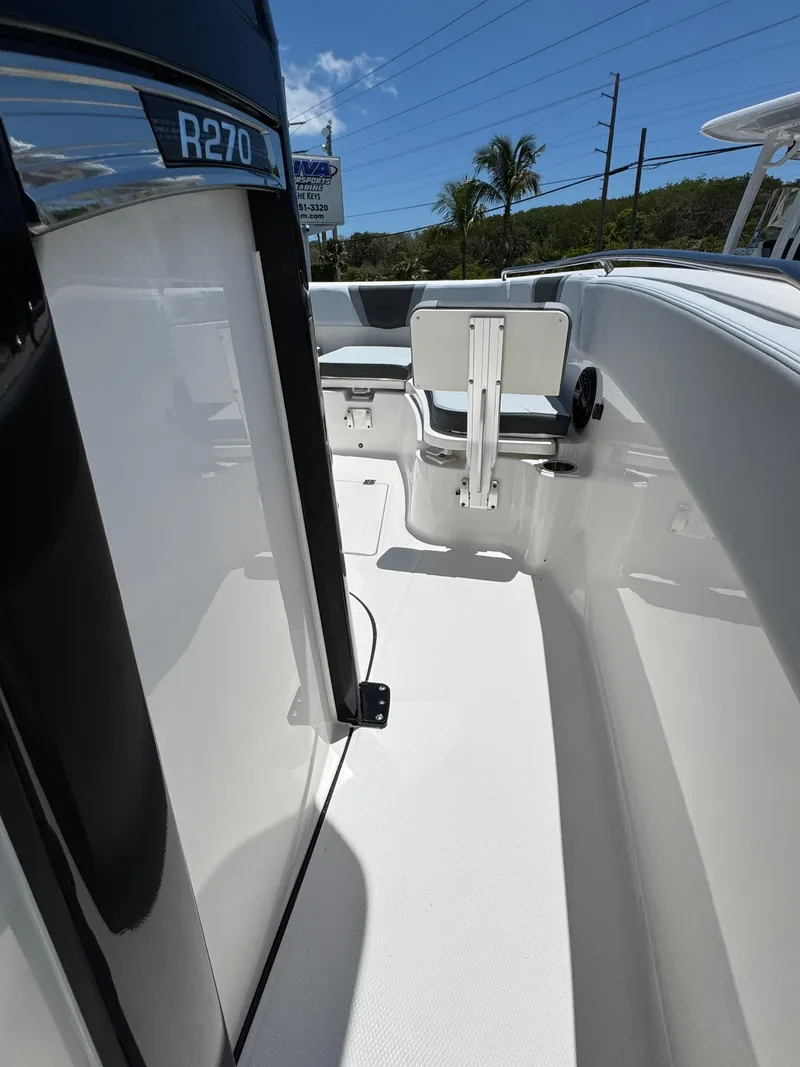 Slide: The Image of 2025 Robalo R270 Center Console boat deck with seating and clear skies. - 20
