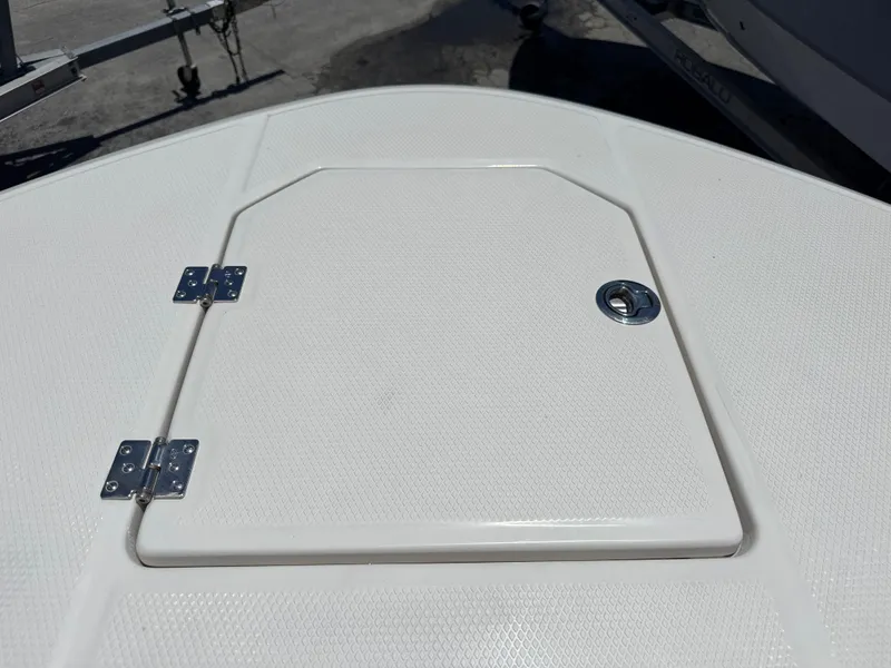 Slide: The Image of 2025 Robalo R270 Center Console boat hatch with metal hinges and latch. - 25