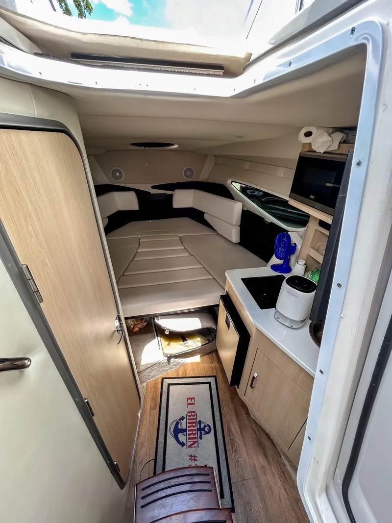 Slide: The Image of Interior of 2023 Regal 26 XO boat, featuring cozy cabin and kitchenette. - 11