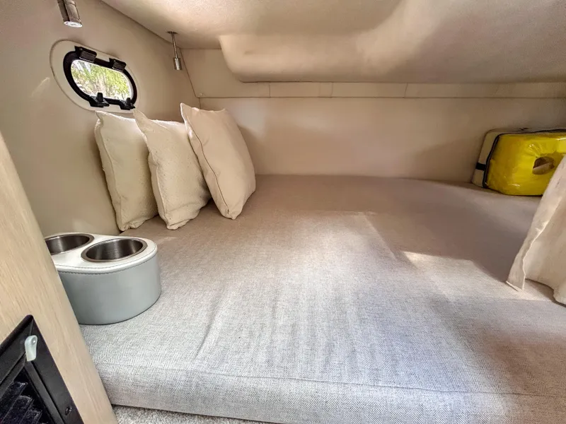 Slide: The Image of Cozy cabin interior of 2023 Regal 26 XO boat with cushions and porthole. - 14