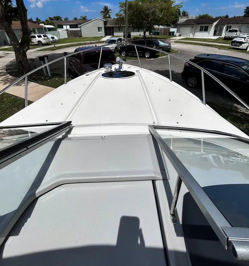 Slide: The Image of 2023 Regal 26 XO boat deck view with open hatch, parked in a residential area. - 19
