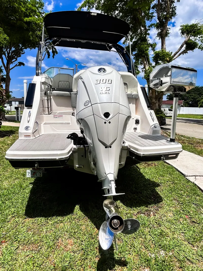 Slide: The Image of 2023 Regal 26 XO boat with powerful outboard motor, parked on grass. - 2