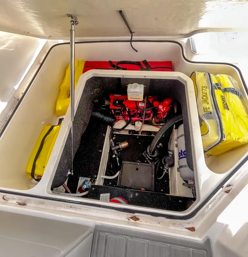 Slide: The Image of 2023 Regal 26 XO boat engine compartment with safety equipment and storage. - 21