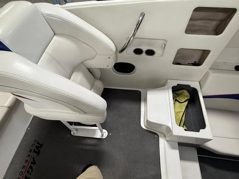 Slide: The Image of White boat interior with cushioned seat, storage compartments, and cup holders in a 2006 Magic 29 Wizard. - 10