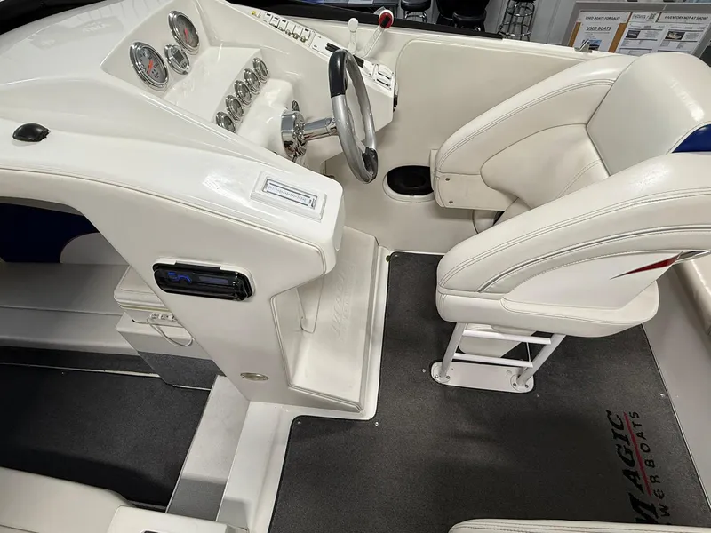 Slide: The Image of Interior of a 2006 Magic 29 Wizard boat with white seating and dashboard. - 12