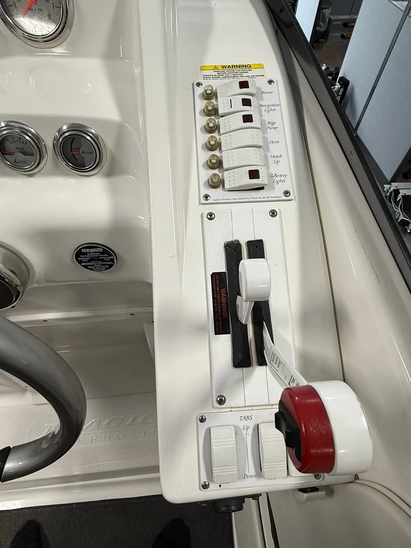 Slide: The Image of Control panel of a 2006 Magic 29 Wizard boat with switches and gauges. - 15