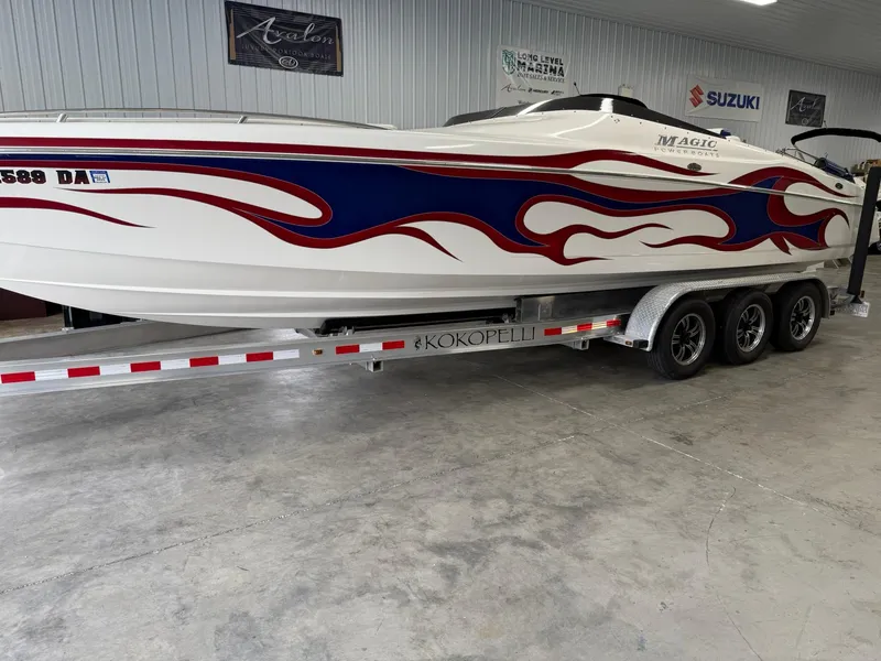 Slide: The Image of 2006 Magic 29 Wizard boat with red and blue flame design on a trailer. - 2