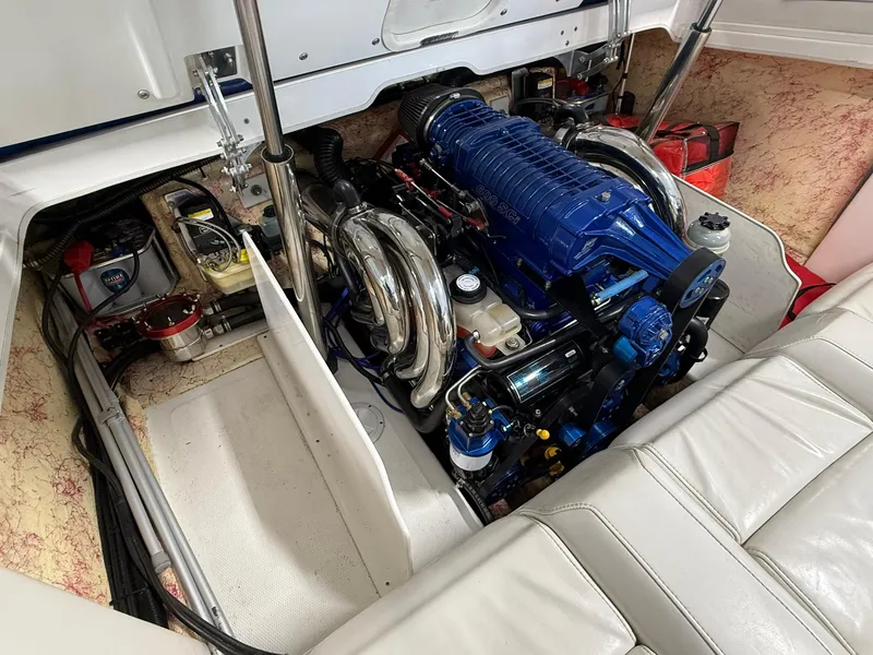 Slide: The Image of Engine compartment of a 2006 Magic 29 Wizard boat, featuring a powerful blue engine. - 20