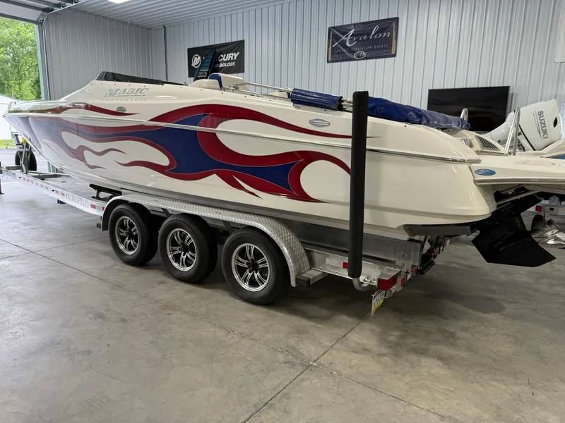 Slide: The Image of 2006 Magic 29 Wizard boat with red and blue flame design on a triple-axle trailer. - 3