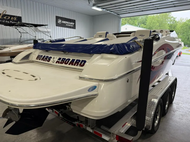 Slide: The Image of 2006 Magic 29 Wizard boat on trailer in garage, featuring "Hoars Aboard" decal. - 5
