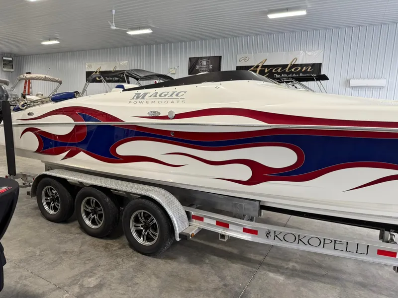 Slide: The Image of 2006 Magic 29 Wizard boat with red and blue flame design on trailer in showroom. - 6