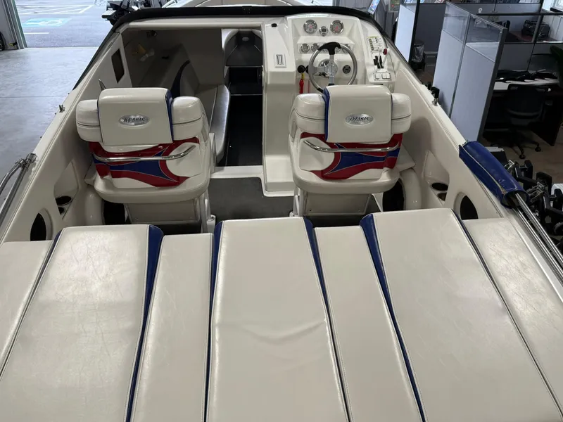 Slide: The Image of 2006 Magic 29 Wizard boat interior with white and red seating, steering wheel, and dashboard. - 7