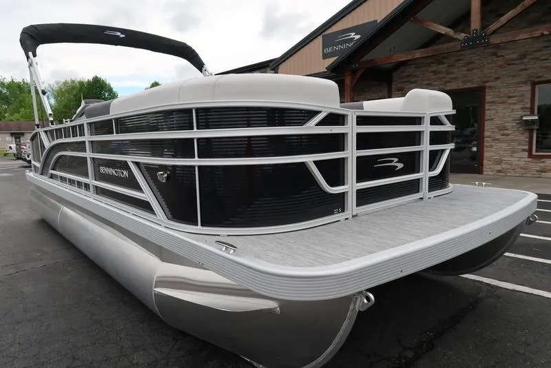 Slide: The Image of 2025 Bennington S Swingback 22 SSB Limited pontoon boat, sleek design, parked outdoors. - 4