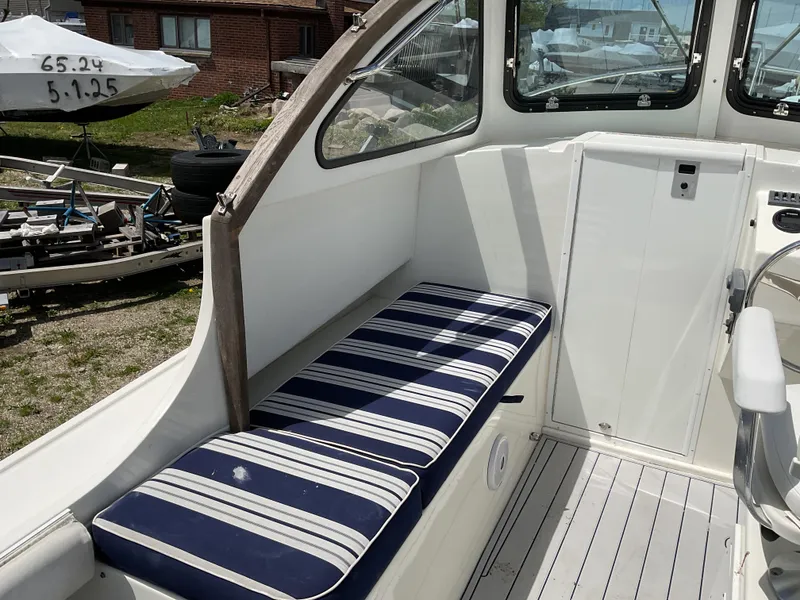 Slide: The Image of 2015 Steiger Craft 21 DV Block Island boat interior with striped seating and white paneling. - 10