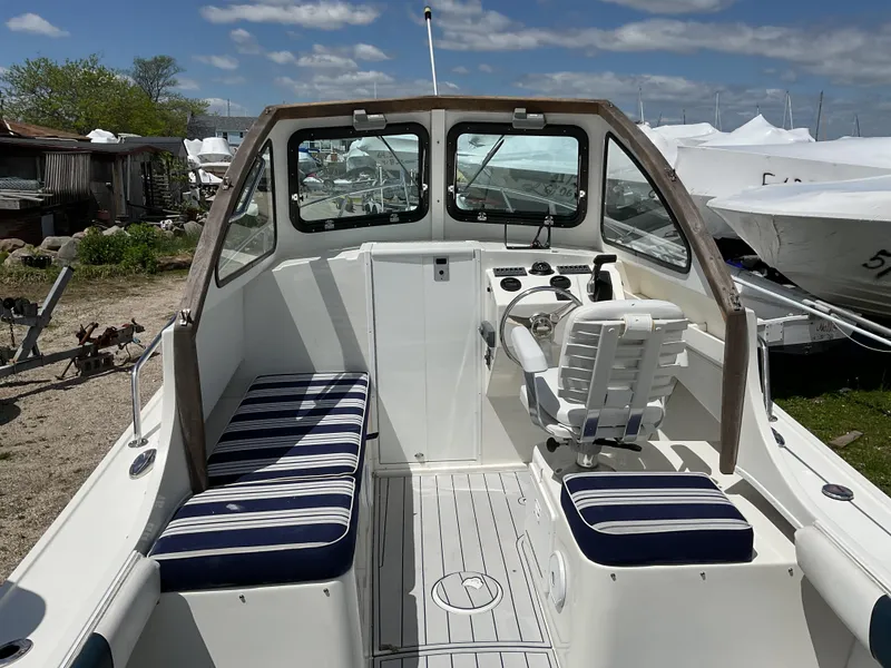 Slide: The Image of 2015 Steiger Craft 21 DV Block Island boat interior with striped seating and steering console. - 11