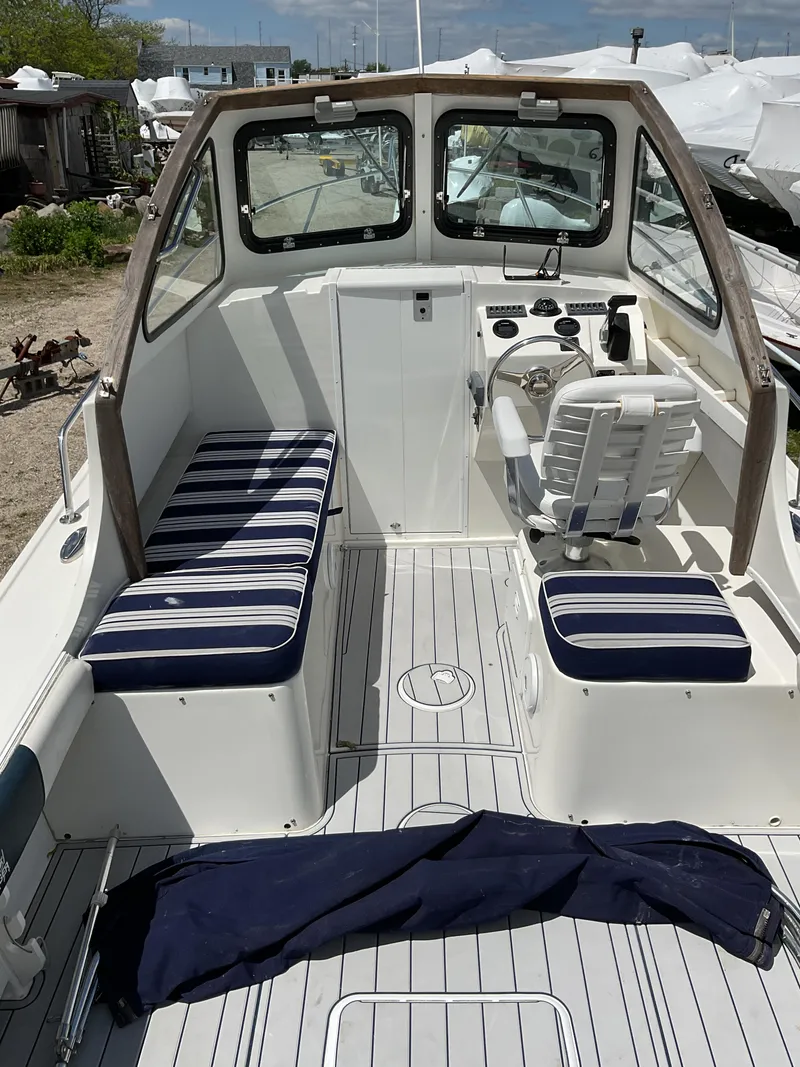 Slide: The Image of 2015 Steiger Craft 21 DV Block Island boat interior with striped seating and steering console. - 12