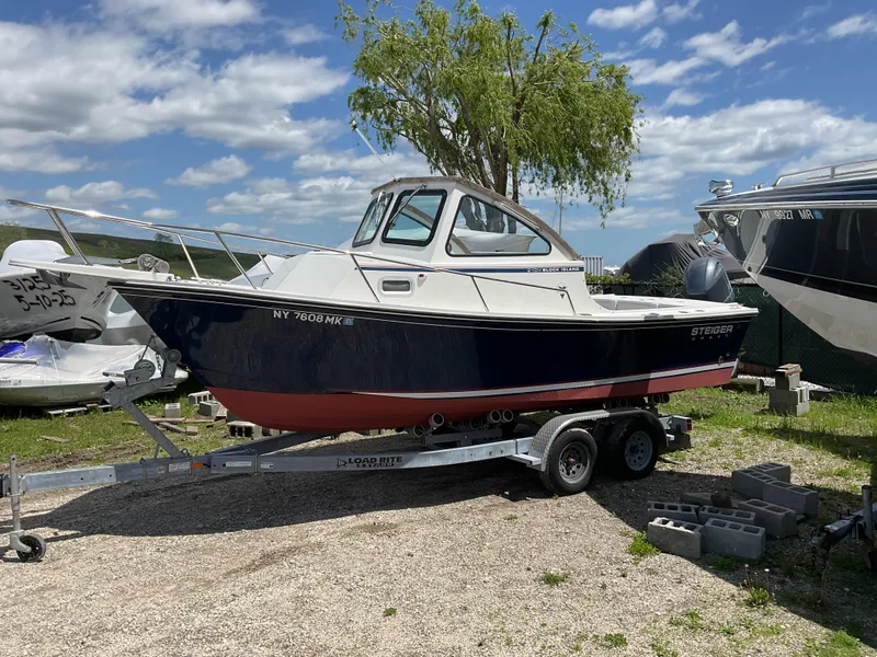 Slide: The Image of 2015 Steiger Craft 21 DV Block Island boat on trailer, parked outdoors under a blue sky. - 2