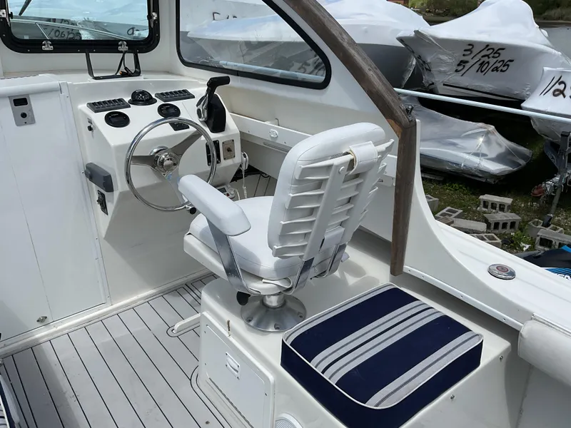 Slide: The Image of 2015 Steiger Craft 21 DV Block Island boat interior with steering wheel and seating. - 9