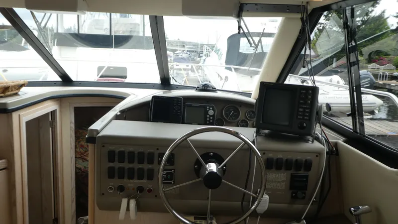Slide: The Image of 1996 Bayliner 3488 Avanti Command Bridge helm with steering wheel and navigation equipment. - 12