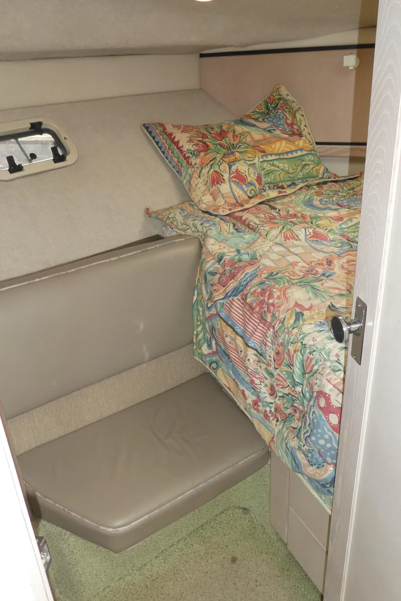 Slide: The Image of 1996 Bayliner 3488 Avanti Command Bridge cabin with colorful bedding and seating area. - 14