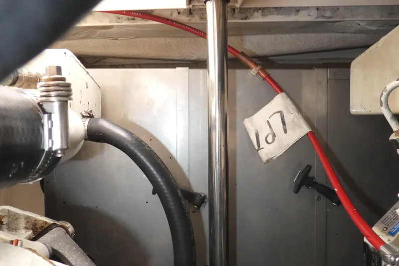 Slide: The Image of Engine compartment of 1996 Bayliner 3488 Avanti Command Bridge with visible hoses and metal components. - 31