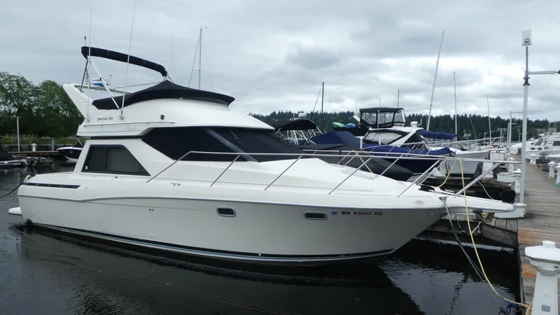 Slide: The Image of 1996 Bayliner 3488 Avanti Command Bridge docked at a marina under cloudy skies. - 32