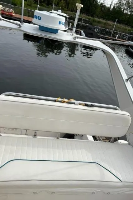 Slide: The Image of 1996 Bayliner 3488 Avanti Command Bridge with white seating and radar, docked on calm water. - 36