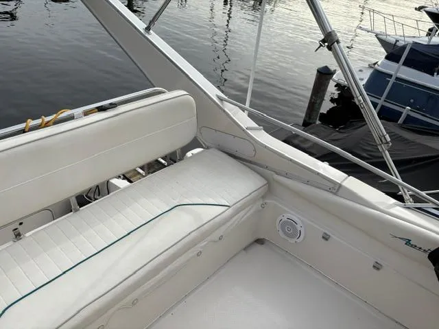 Slide: The Image of 1996 Bayliner 3488 Avanti Command Bridge with white seating, docked by calm waters. - 37