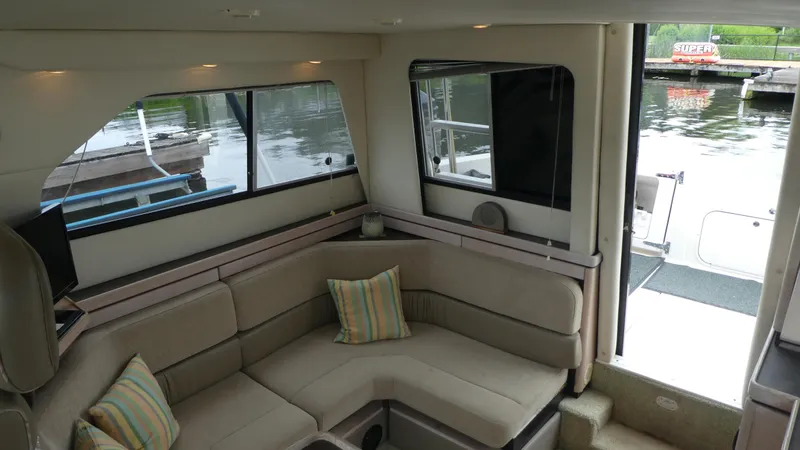 Slide: The Image of Interior of 1996 Bayliner 3488 Avanti Command Bridge with beige seating and striped pillows. - 4