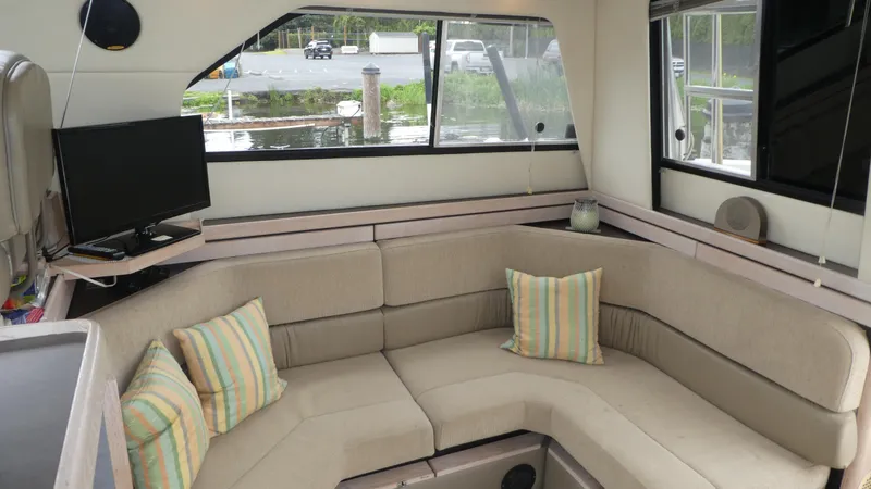 Slide: The Image of Interior of 1996 Bayliner 3488 Avanti Command Bridge with cozy seating and striped cushions. - 6