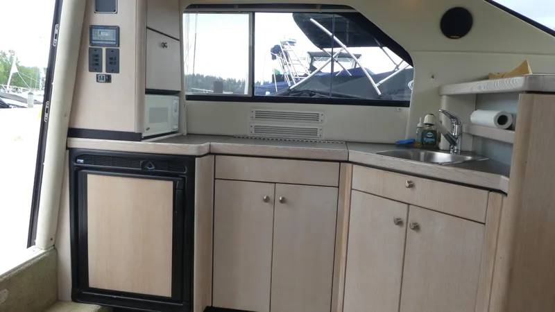 Slide: The Image of Interior of 1996 Bayliner 3488 Avanti Command Bridge, featuring kitchen area with sink and cabinets. - 7