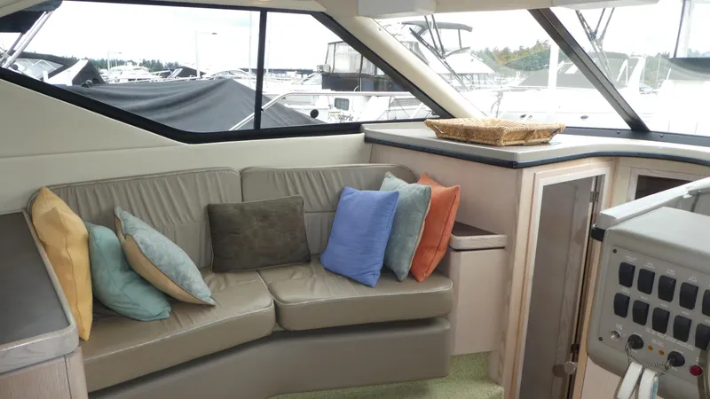 Slide: The Image of Interior of 1996 Bayliner 3488 Avanti Command Bridge with cushioned seating and colorful pillows. - 8