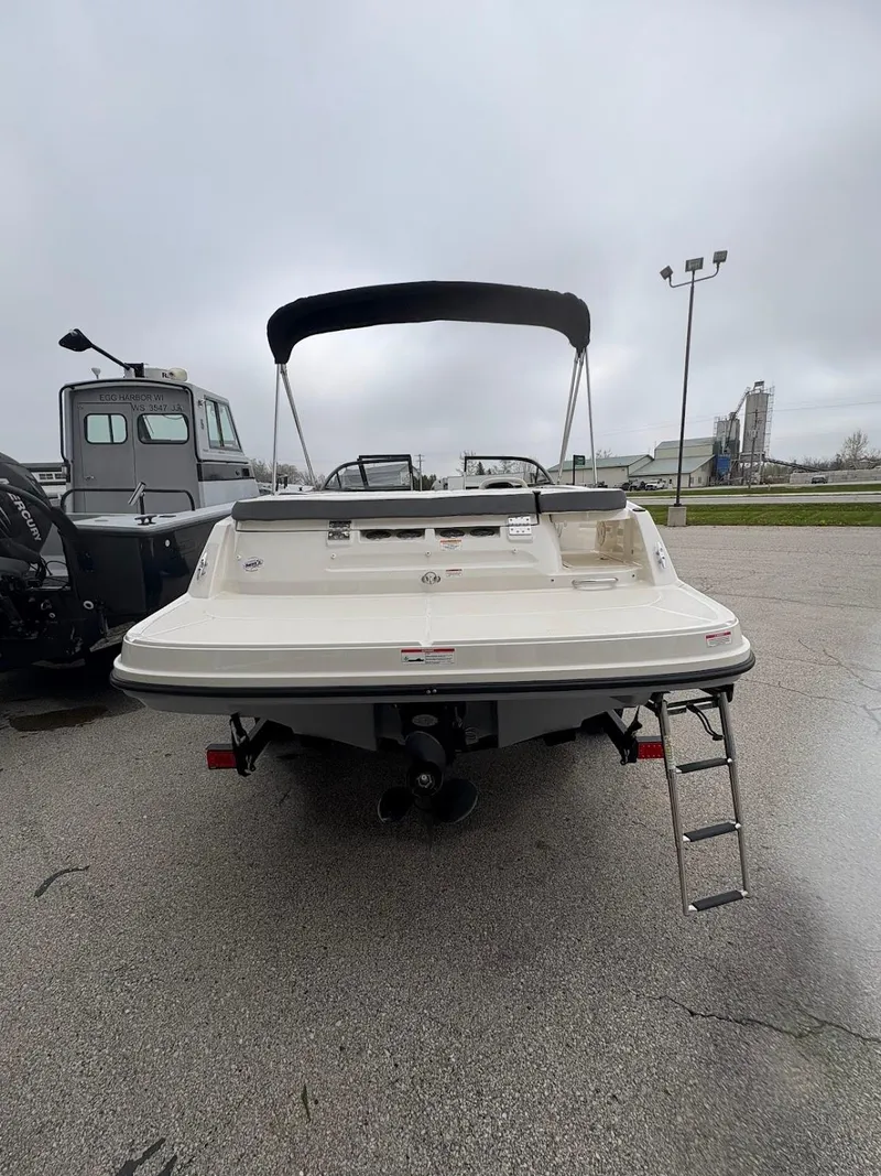 Slide: The Image of 2017 Bayliner VR5 Bowrider boat with canopy and ladder, parked on a wet surface. - 13