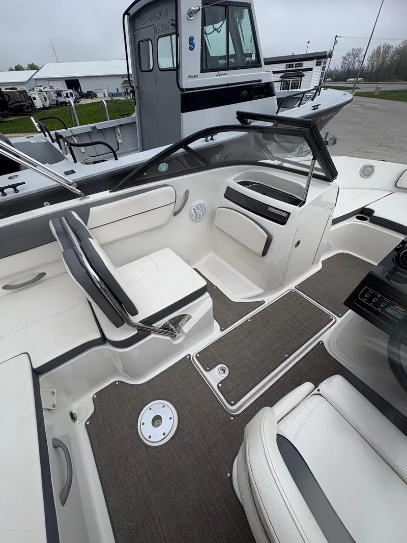 Slide: The Image of 2017 Bayliner VR5 Bowrider interior with seating and dashboard, docked near other boats. - 7