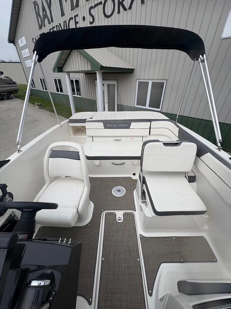 Slide: The Image of 2017 Bayliner VR5 Bowrider with white seating and canopy, docked near a storage facility. - 9