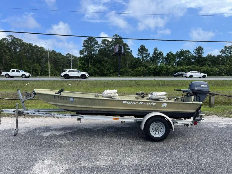 Slide: The Image of 1989 Polar Kraft 15' Jon boat on trailer with Yamaha motor, parked roadside. - 1