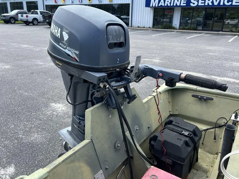 Slide: The Image of 1989 Polar Kraft 15' Jon boat with Yamaha four-stroke outboard motor in a parking lot. - 10