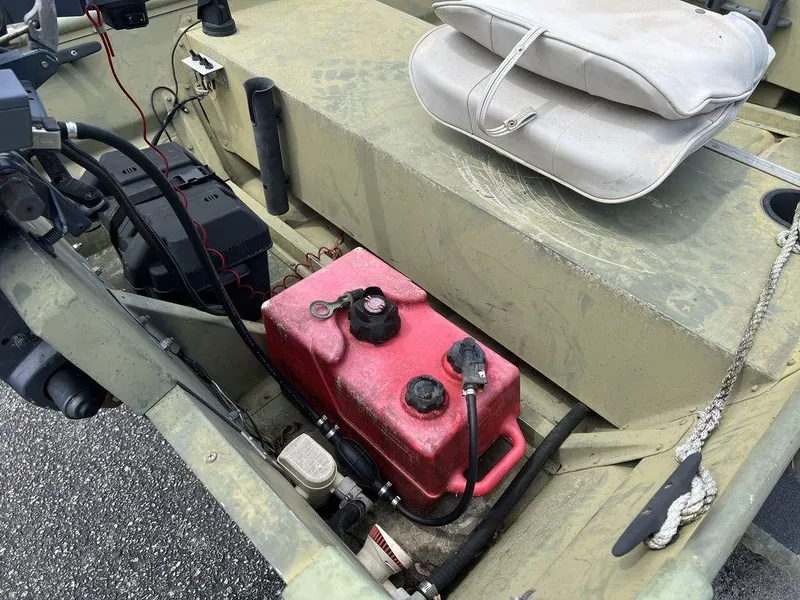 Slide: The Image of 1989 Polar Kraft 15' Jon boat interior with red fuel tank and battery. - 12