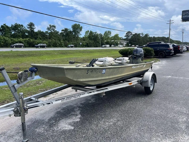 Slide: The Image of 1989 Polar Kraft 15' Jon boat on trailer, parked outdoors under a cloudy sky. - 2