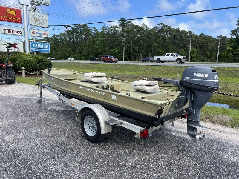 Slide: The Image of 1989 Polar Kraft 15' Jon boat on trailer with Yamaha outboard motor, parked outdoors. - 3