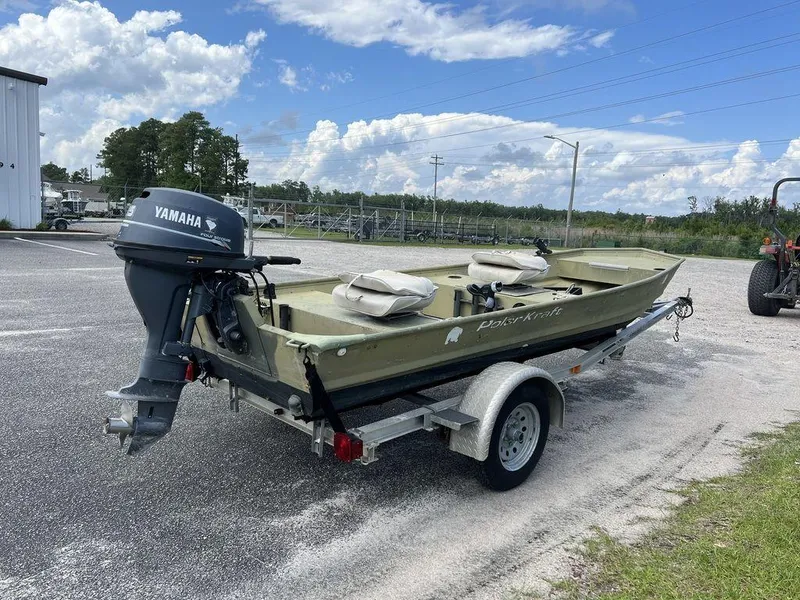 Slide: The Image of 1989 Polar Kraft 15' Jon boat with Yamaha motor on a trailer, parked outdoors. - 6
