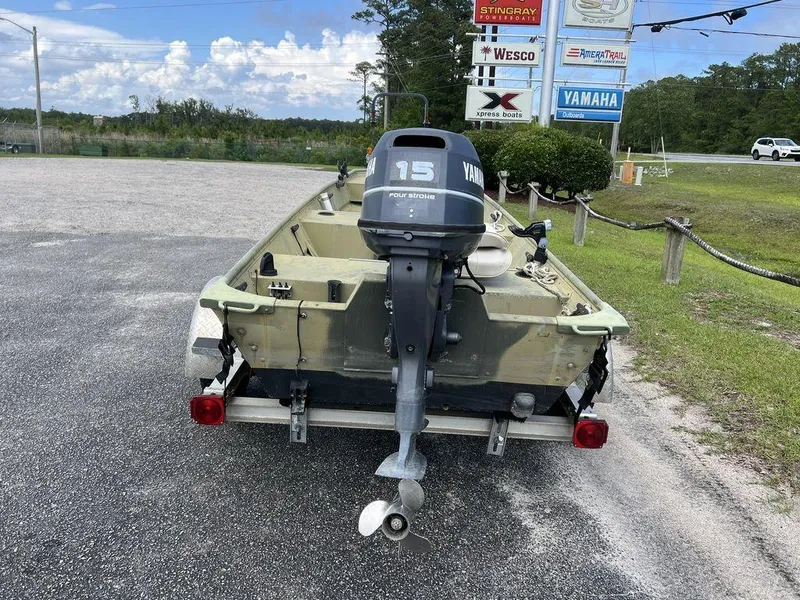 Slide: The Image of 1989 Polar Kraft 15' Jon boat with Yamaha outboard motor in a parking lot. - 7