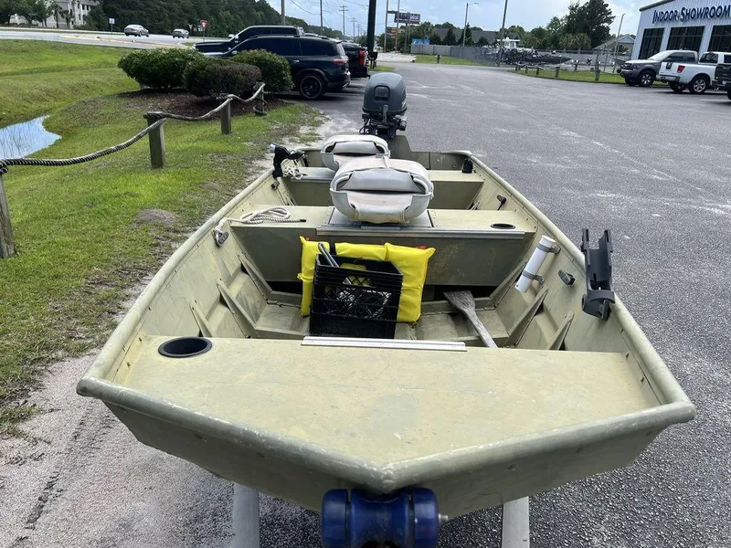 Slide: The Image of 1989 Polar Kraft 15' Jon boat on trailer, parked outdoors near showroom. - 8