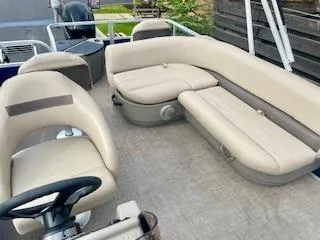 Slide: The Image of 2023 Sun Tracker Bass Buggy 18 DLX pontoon boat with beige seating and steering console. - 4