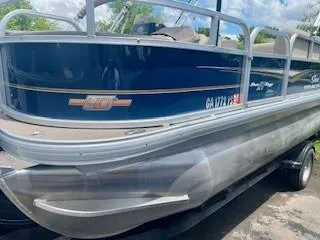 Slide: The Image of 2023 Sun Tracker Bass Buggy 18 DLX pontoon boat on trailer, side view. - 6